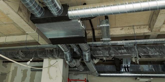 HVAC ducts are installed in a building under construction.