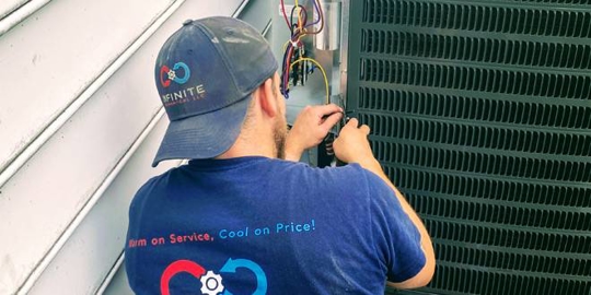 An HVAC technician services an AC unit.