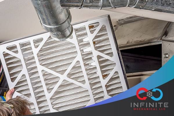 Close-up image of a person replacing an air filter in a home's HVAC system.